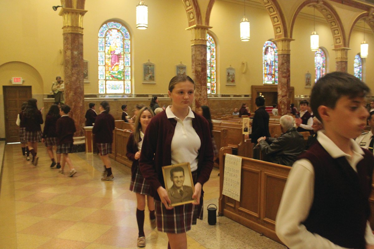 PATRIOTIC PRAYERS: - Students carried photos of loved ones as they walked around the church honoring them for their service. St. Rocco School held its Veterans Day Prayer Service Wednesday, Nov. 9 at St. Rocco Church, 931 Atwood Ave., Johnston. Students from St. Rocco School read poems that they wrote, carried photos of loved ones, sang patriotic songs and prayed for all veterans.  Also, the school held a “Dress Down Day” for "Operation Christmas Stocking" where students dressed in red, white and blue, along with donating a dollar for the cause. Proceeds will go toward filling stockings for soldiers in the 43rd MP Brigade.